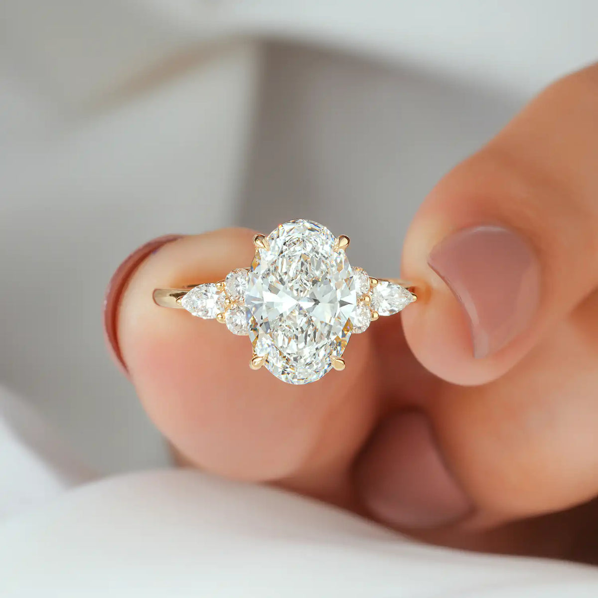 Oval Lab Grown Diamond Engagement Ring with Pear and Round Side Stones