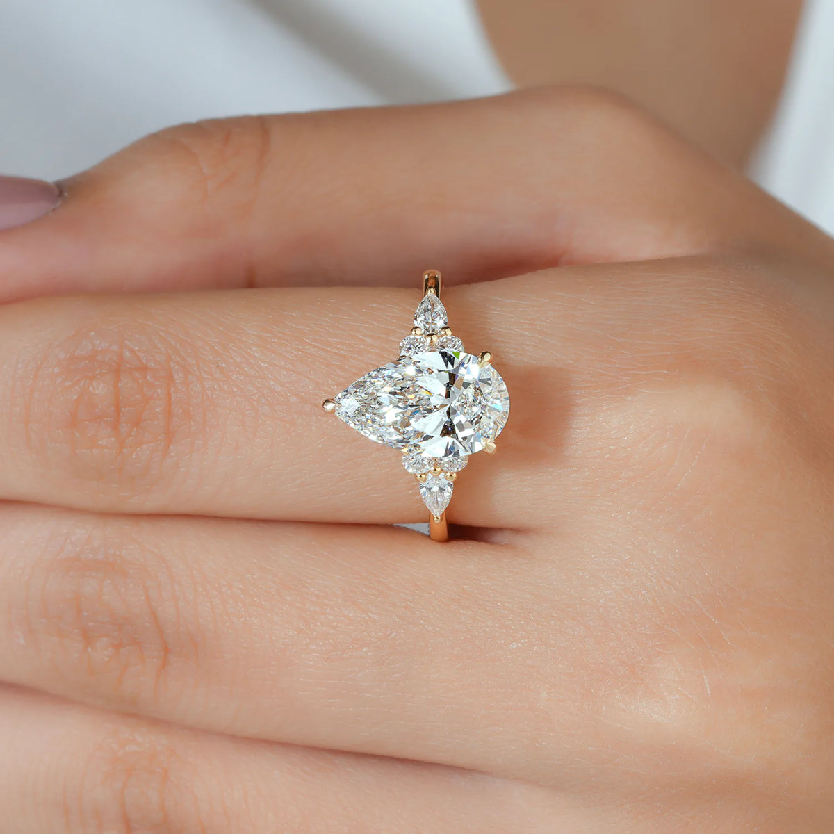 Pear Cut Lab Grown Diamond Engagement Ring with Round and Pear Cluster Accents